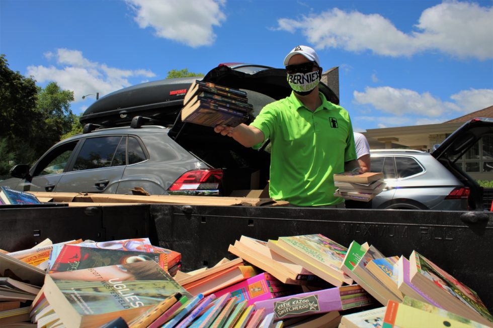 a volunteer sorts books into a massive bin