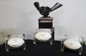 The Patrick Mannelly award featuring two bronze hands clasping a football, and three signed white footballs