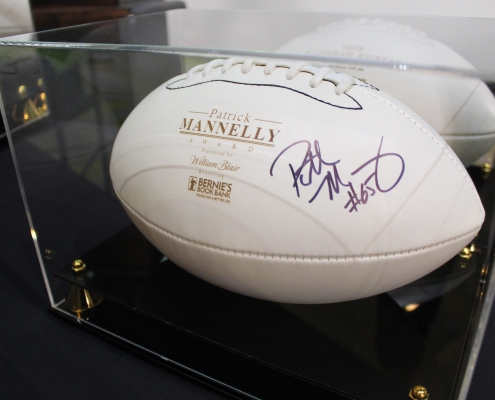 a signed white football with gold embossed text that reads Patrick Mannelly Award