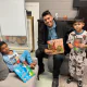 Officer Magellon with two boys holding Spanish-language books