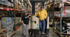 two volunteers stand in a warehouse of donated books