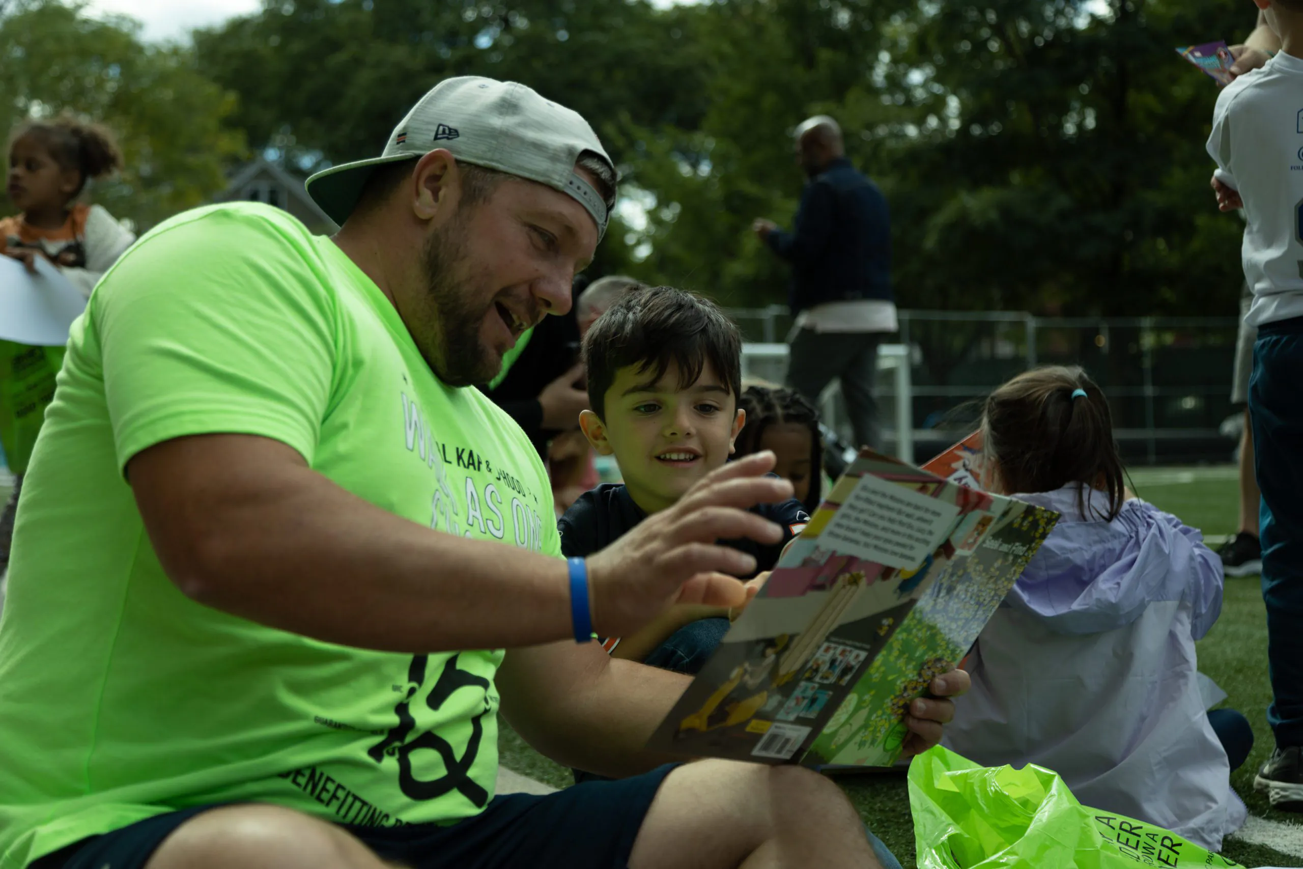 an adult reads to a smiling child at a Bernie's Book Bank event