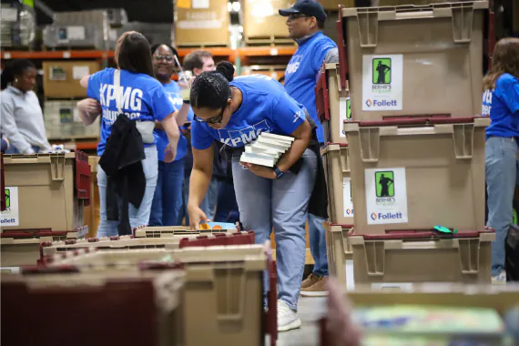 a Volunteer packs books into large bins
