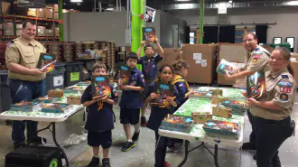 kids and adults organize donated books on folding tables