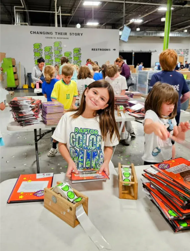 a dozen kids pack books and apply bright green Bernie's stickers