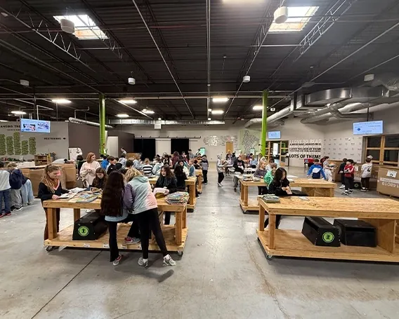 Volunteers sort books in the Bernie's Book Bank offices, surrounded by clean cement floors and vibrant green poles