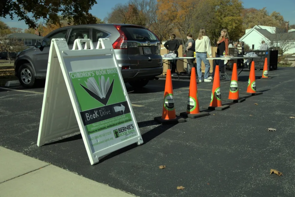 a sandwich board in a parking lot advertises a Bernie's Book drive