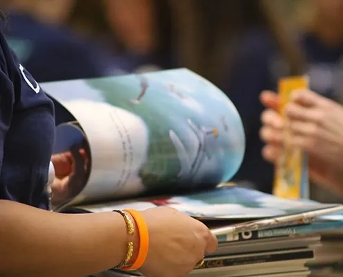 Close-up of an adult paging through a picture book about an airplane
