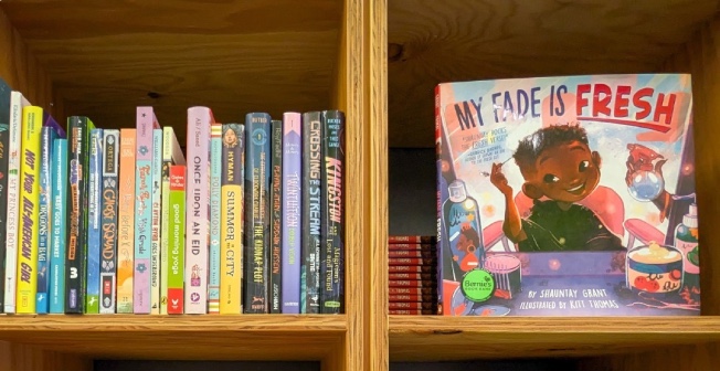four bookshelves with culturally-relevant books for kids, including My Fade is Fresh by Shaunty Green