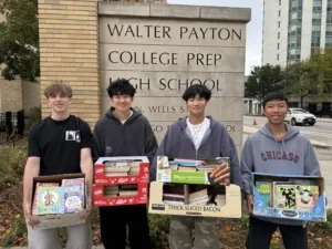 Boys with Books officers Connor Verigan, Gabriel Moy, Matthew Tong and Brady Eng posing with boxes of books