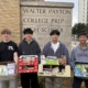 Boys with Books officers Connor Verigan, Gabriel Moy, Matthew Tong and Brady Eng posing with boxes of books