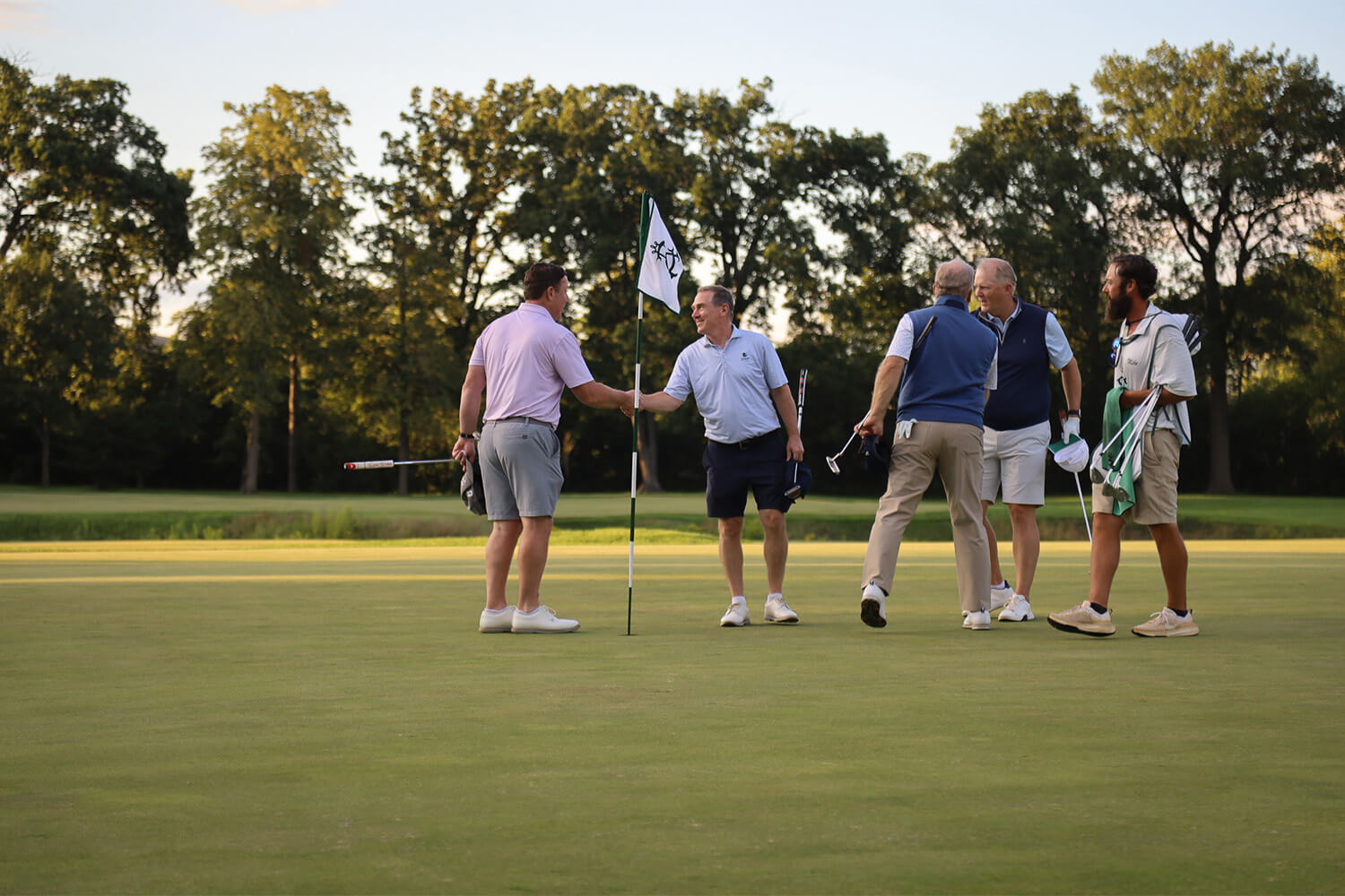 Players shaking hands after a round at the Bernie's Cup golf event