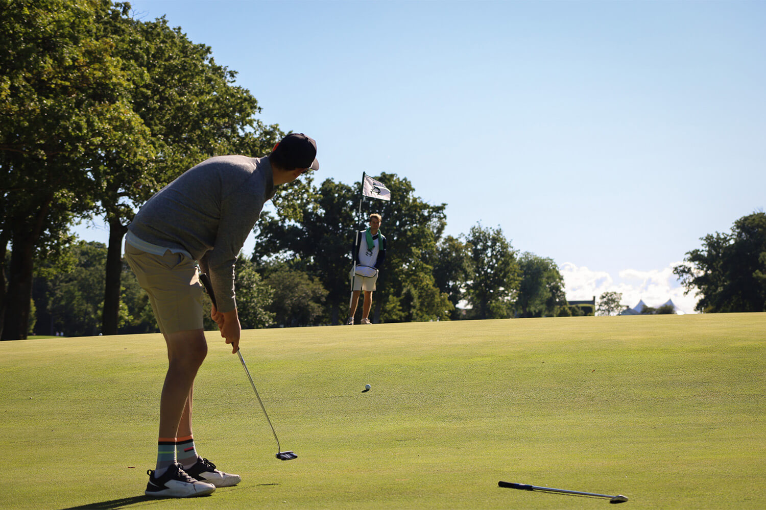 A person putting up a hill on the green at the Bernie's Cup golf event