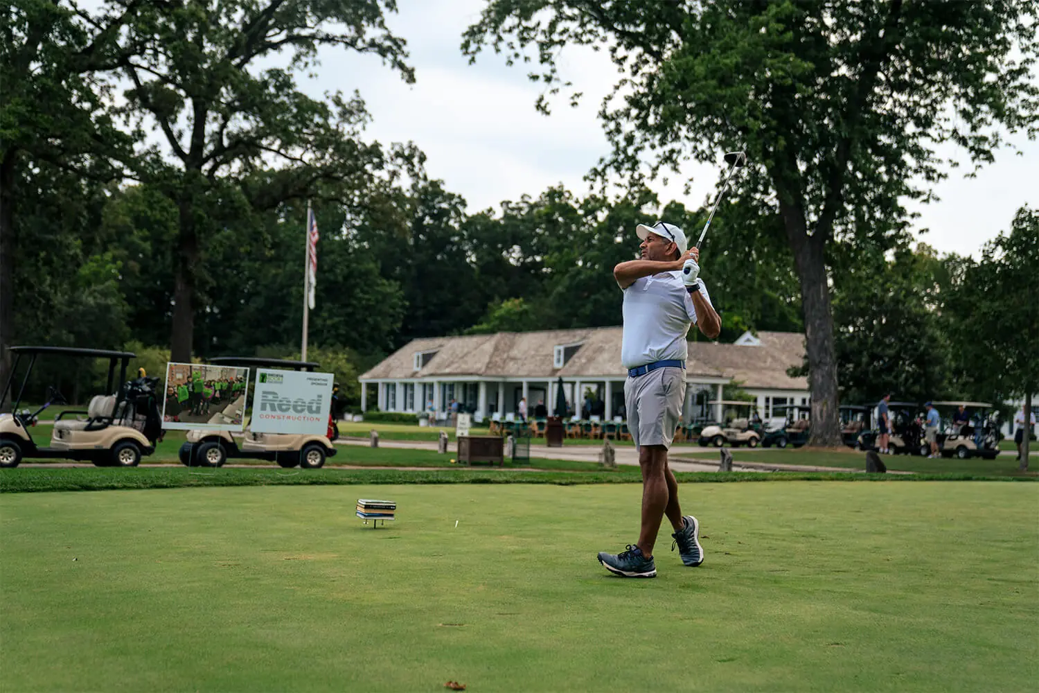 Individual taking their tee shot at a golf event
