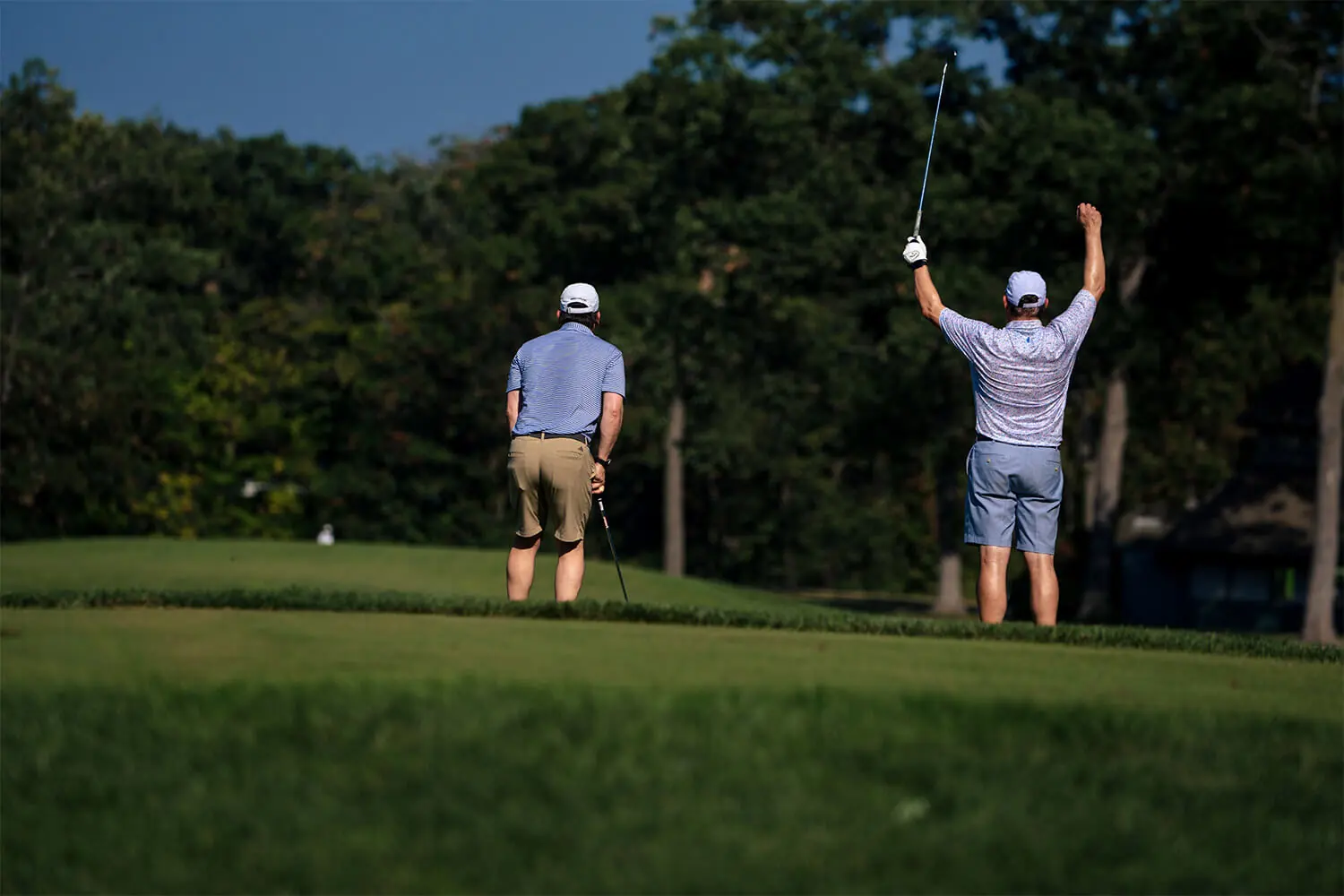 Players watching a golf shot and cheering at the Bernie's Cup golf event