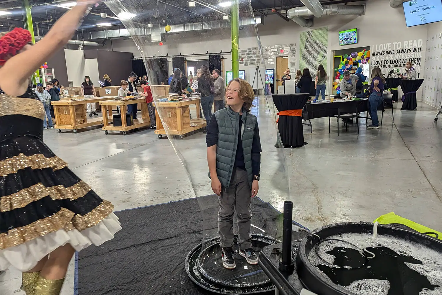 An older child standing in a bubble machine having fun