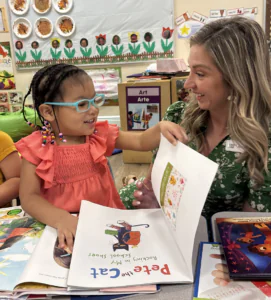 Executive Director Amy Bott distributing books to a classroom