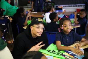 Ryan Rollins at George Washing Carver Academy delivering green book bags