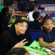 Ryan Rollins at George Washing Carver Academy delivering green book bags