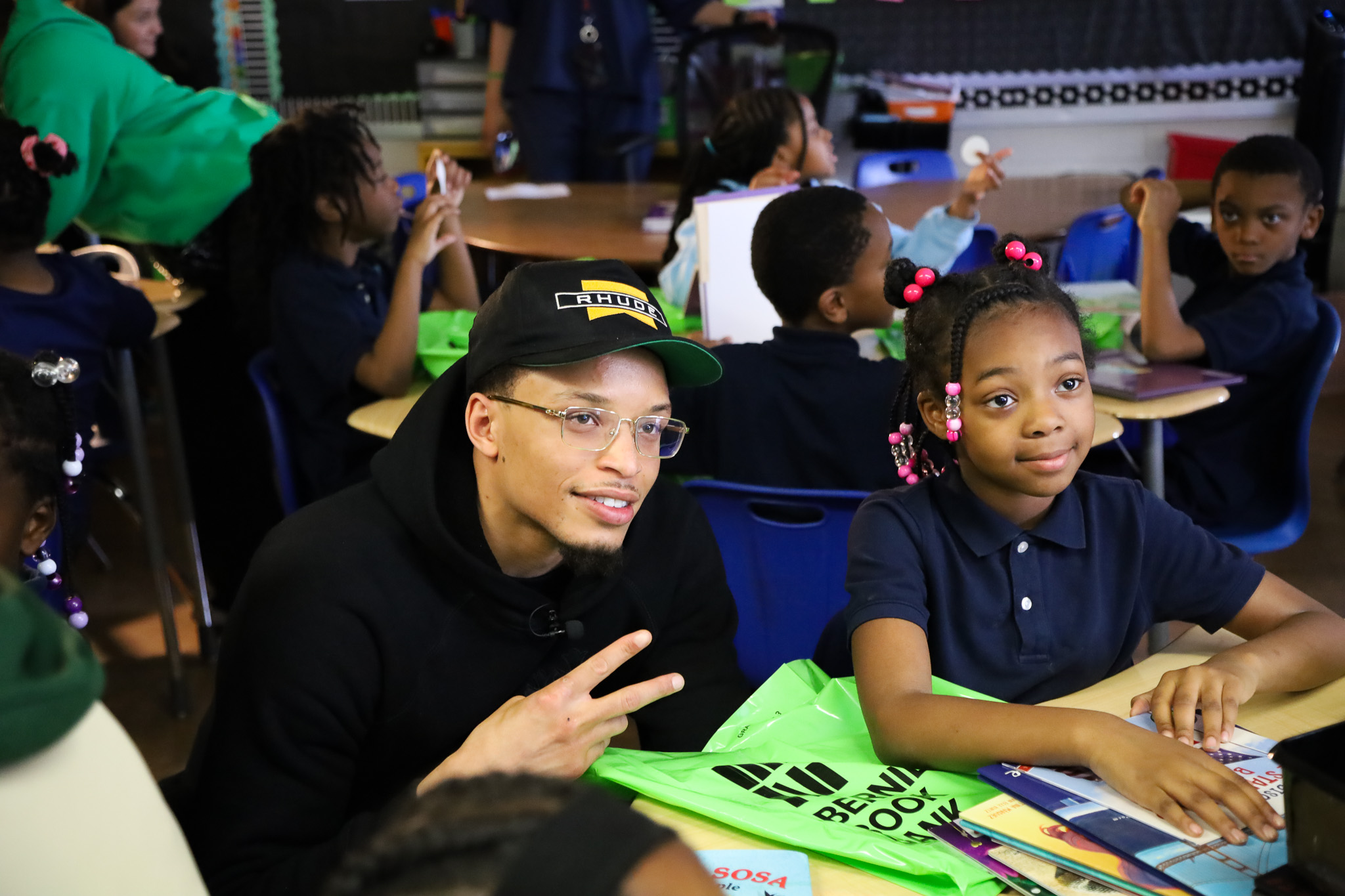 Ryan Rollins at George Washing Carver Academy delivering green book bags